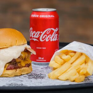 Delicious cheeseburger with fries and a can of soda, perfect for a tasty meal.