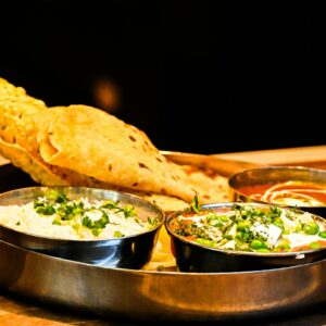 Exquisite Indian thali with naan bread, paneer curry, and aromatic rice served on a wooden table.