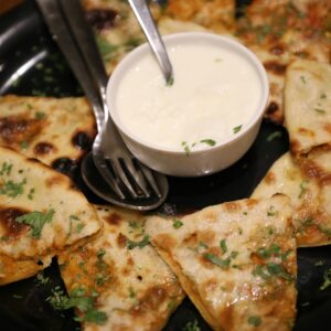 Tasty Indian paratha slices served with creamy yogurt. Perfect snack or meal.