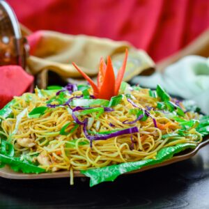 Vibrant noodle dish artistically presented with assorted vegetables, capturing the essence of Asian cuisine.