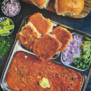 Delicious spicy pav bhaji with garnishes, perfect for a flavorful Indian lunch.