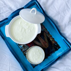 Top view of two ceramic bowls with yogurt on a decorative blue tray.