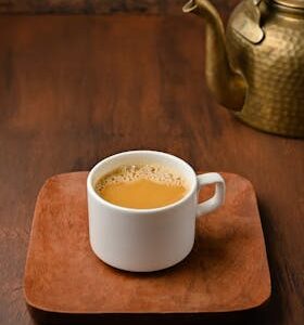 Enjoy a traditional Indian chai served on a wooden platter with a vintage brass kettle.