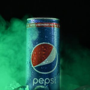 Chilled Pepsi can in icy environment with green mist effect.