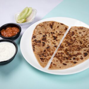 Close-up of Indian paratha served with chutneys and salad. Perfect for food photography.